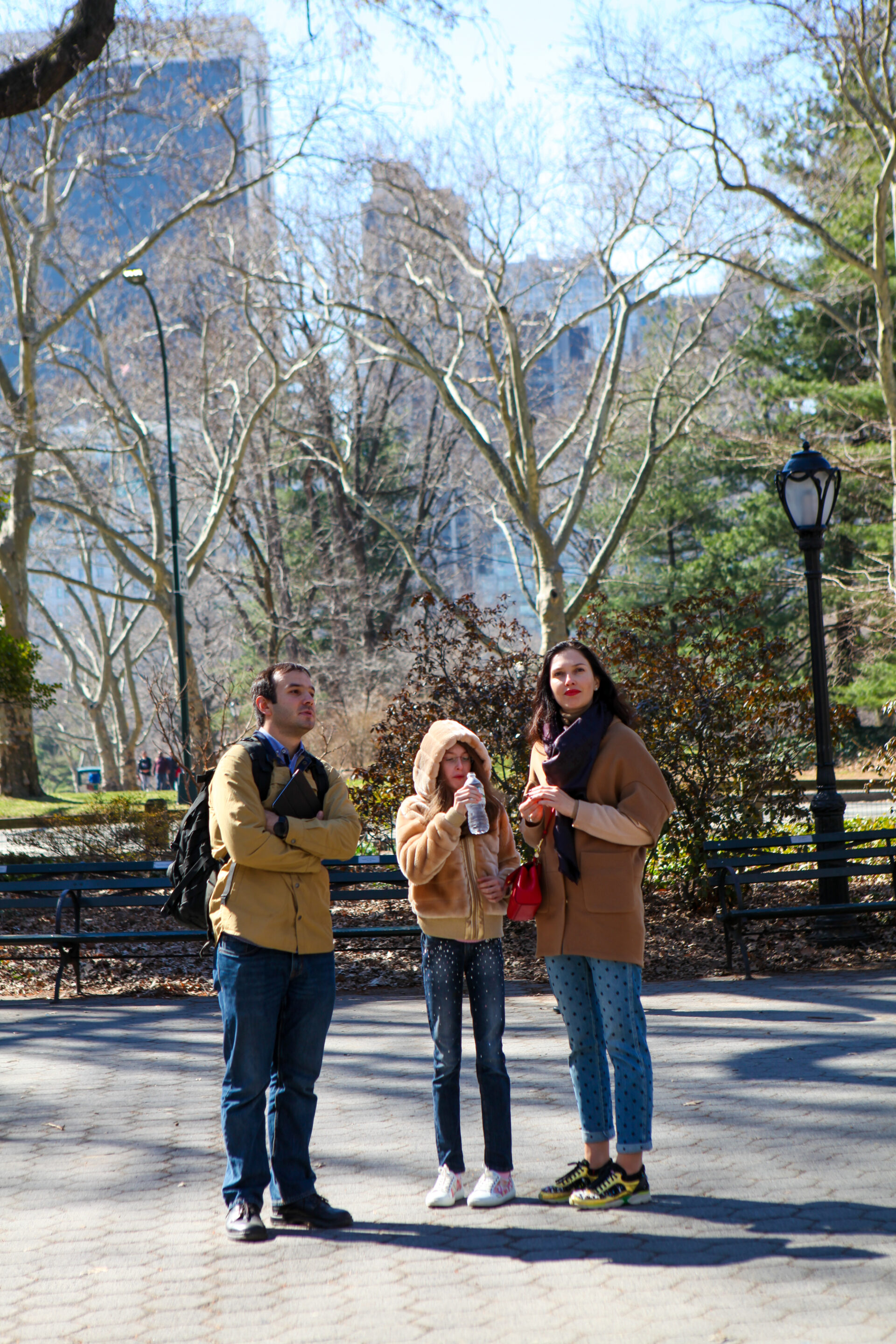 a guide is standing next to this 2 guests while on a tour of central park