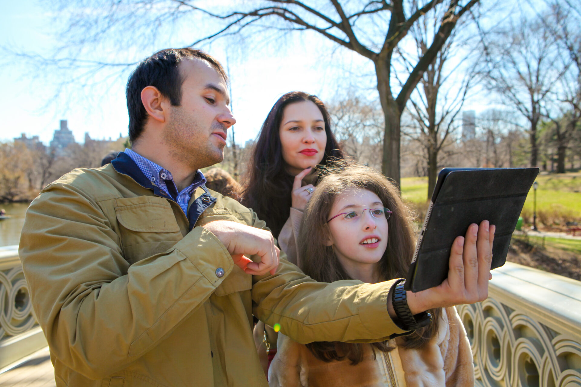 rare photo of Slava using an Apple product (iPad); he is showing pictures to his guests feigning deep interest, shot at the Bow Bridge in Central Park
