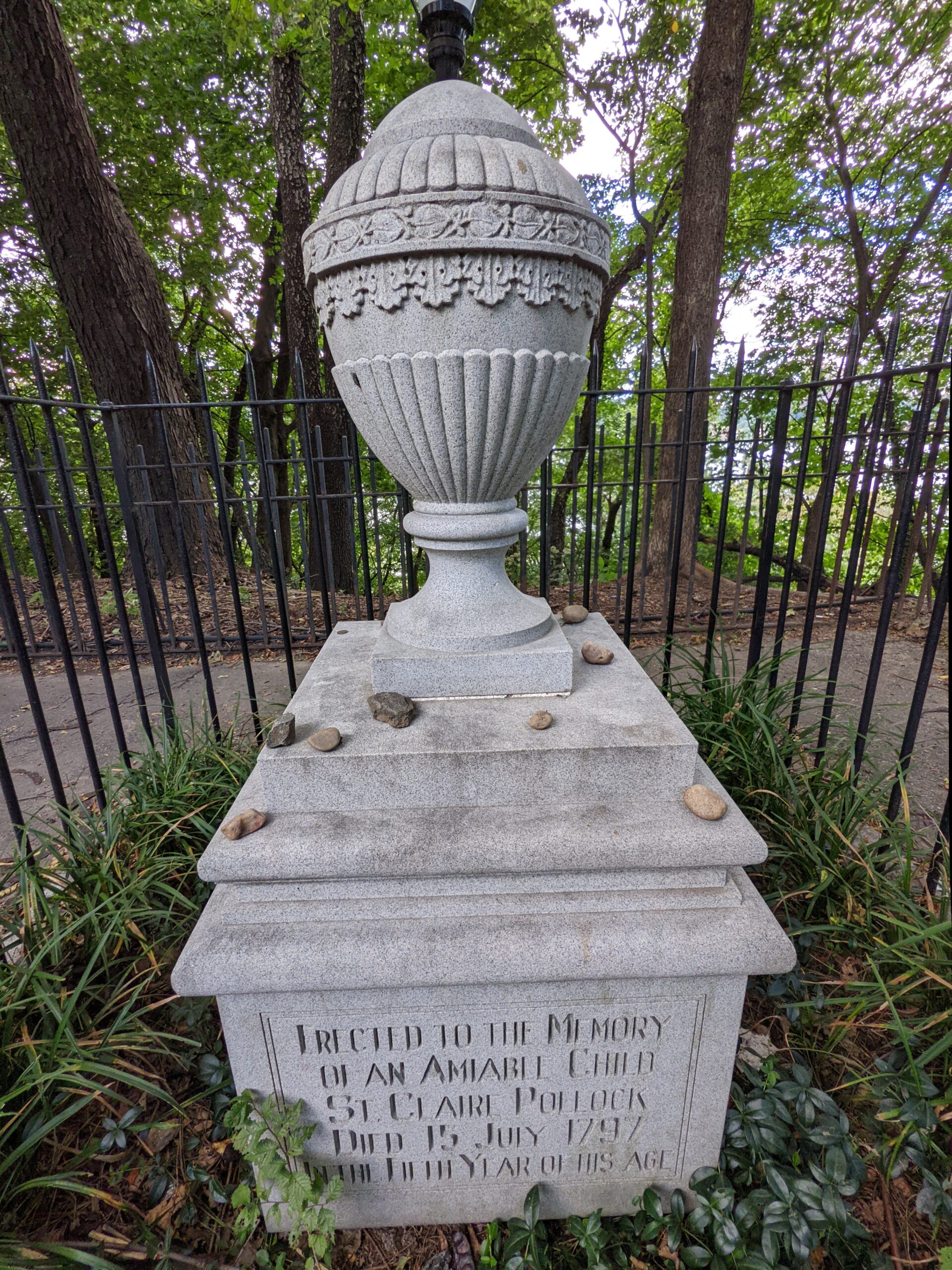 a small fenced urn-like gravestone