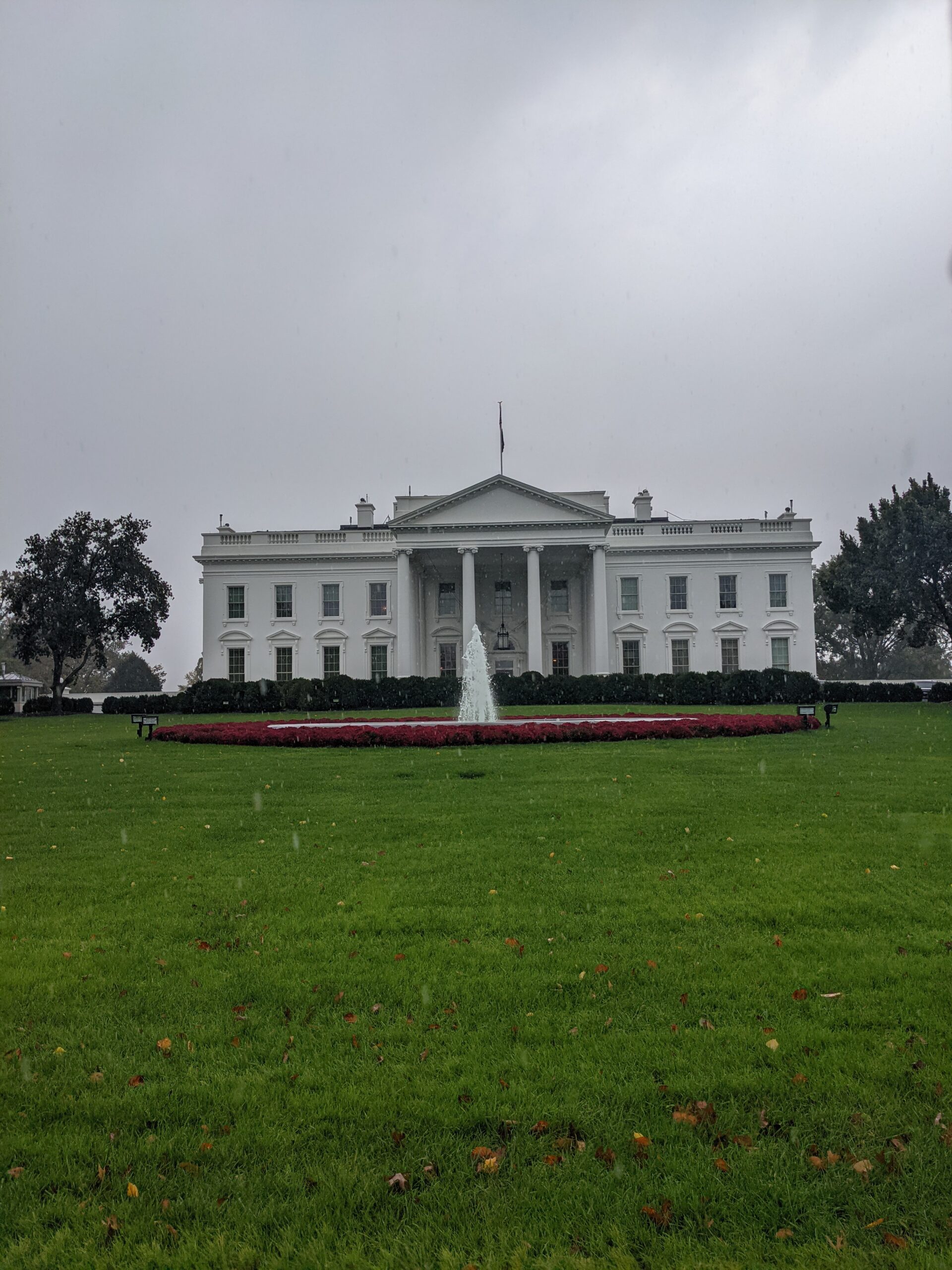 white house with a fountain in the front
