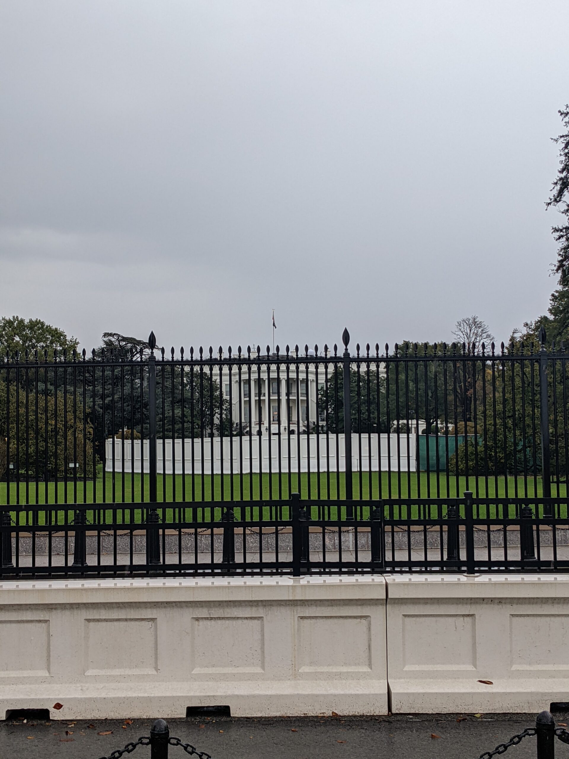 white house from the back from behind the fence and from some distance