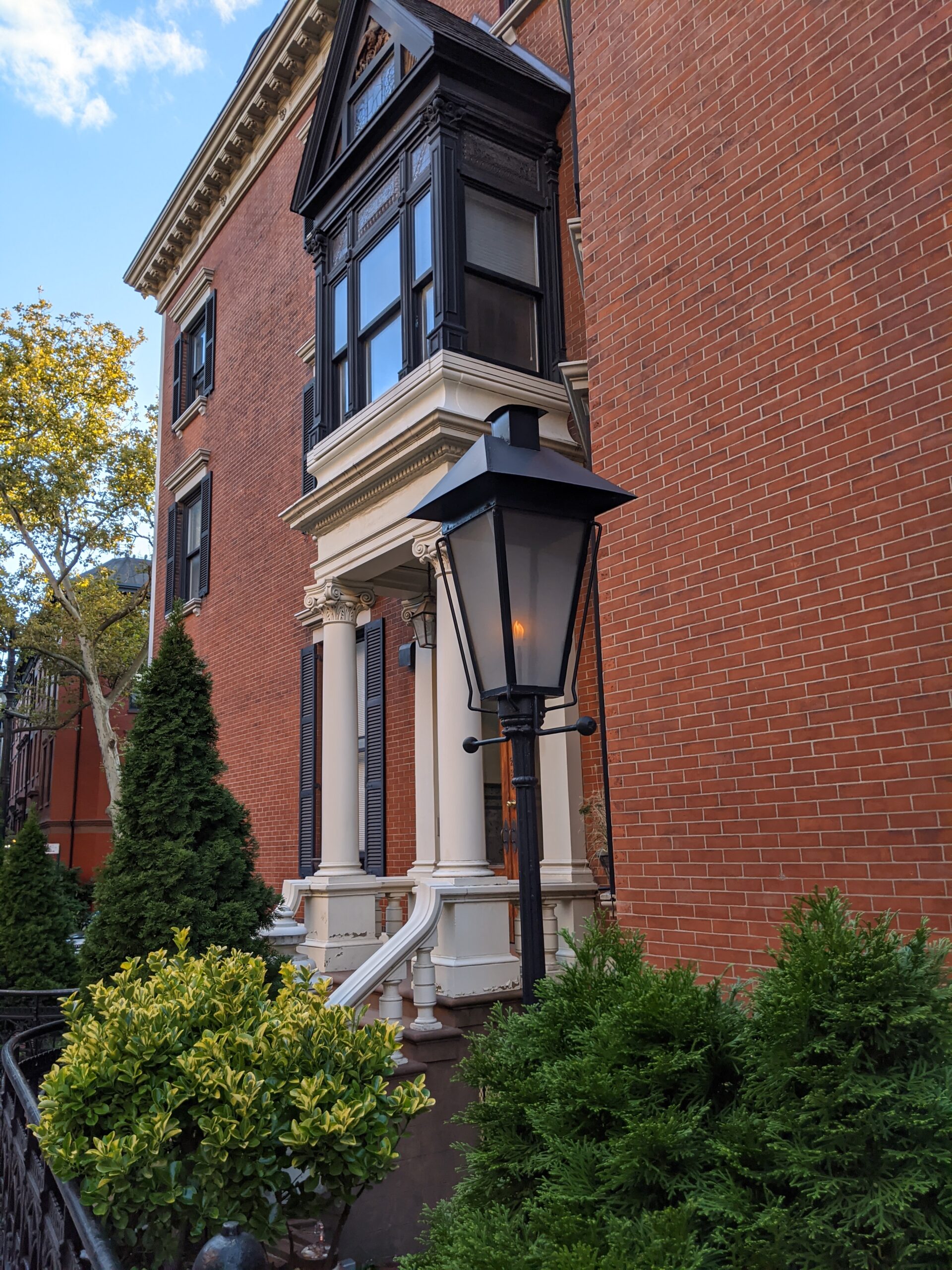 an old fashioned lamppost in front of a red brick building