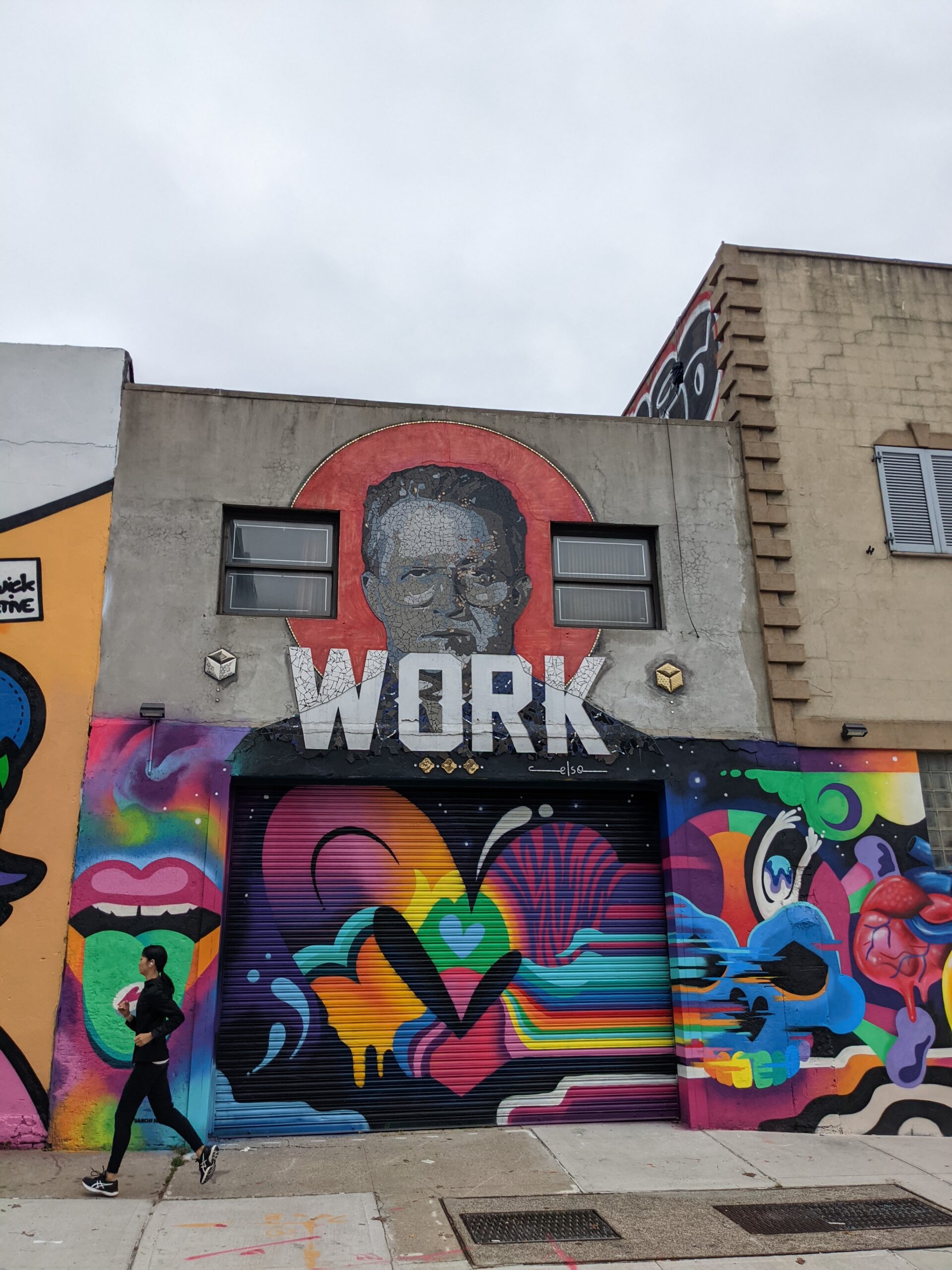 mural on a 2 story building with the word WORK on top